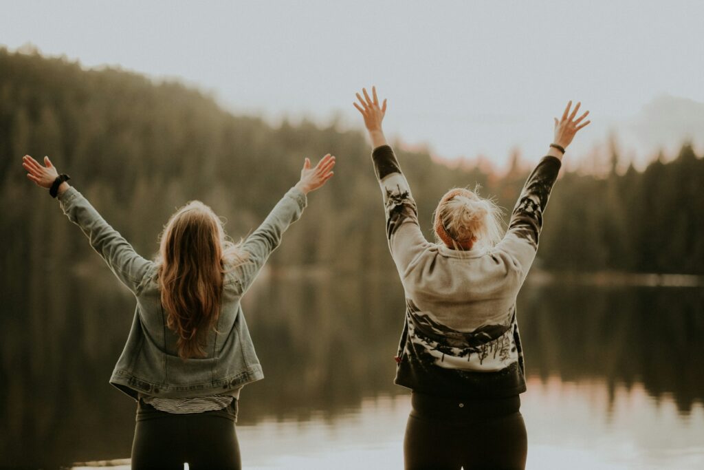 Two happy women relaxing at the lake.